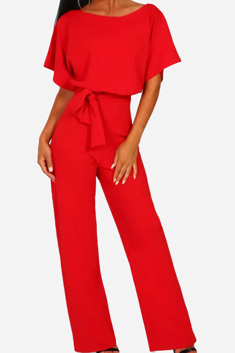 Woman wearing a red chic short-sleeved wide-leg jumpsuit with a waist belt against a white background