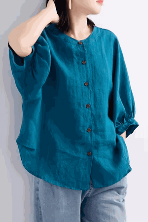 Relaxed loose breathable linen blouse in teal with button-down front and 3/4 sleeves worn with jeans