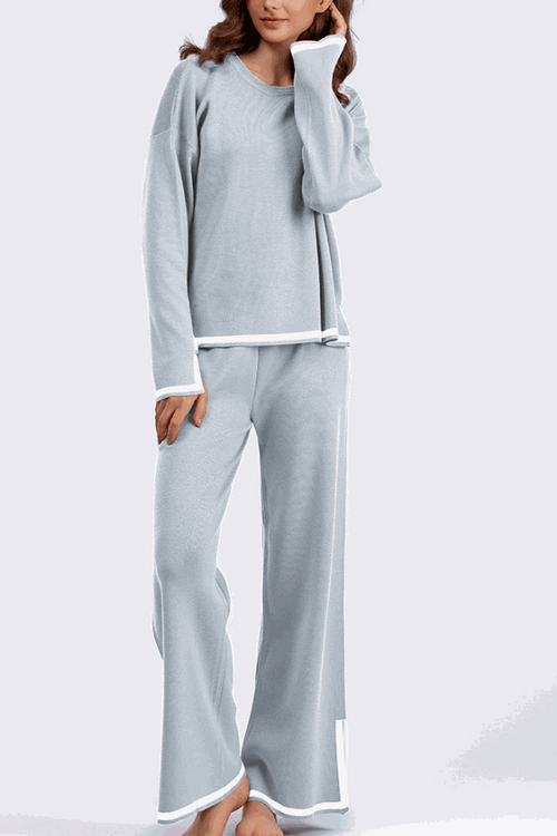 Long sleeved relaxed fit lounge two-piece set in light blue with white trim, featuring a loose sweater and wide-leg palazzo pants.