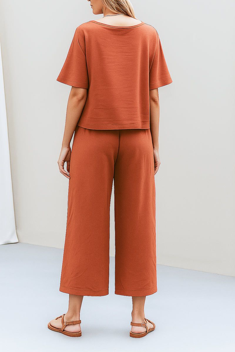 Back view of a woman wearing loose fit co-ord set in rust color with wide-leg pants and relaxed short sleeve top