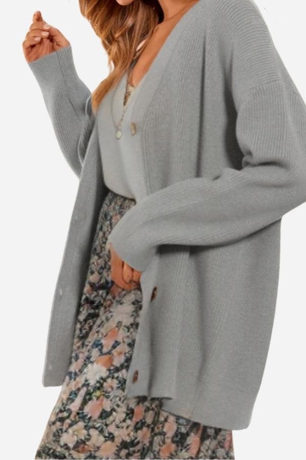 Relaxed fit oversized gray knitwear cardigan with buttons worn over floral dress