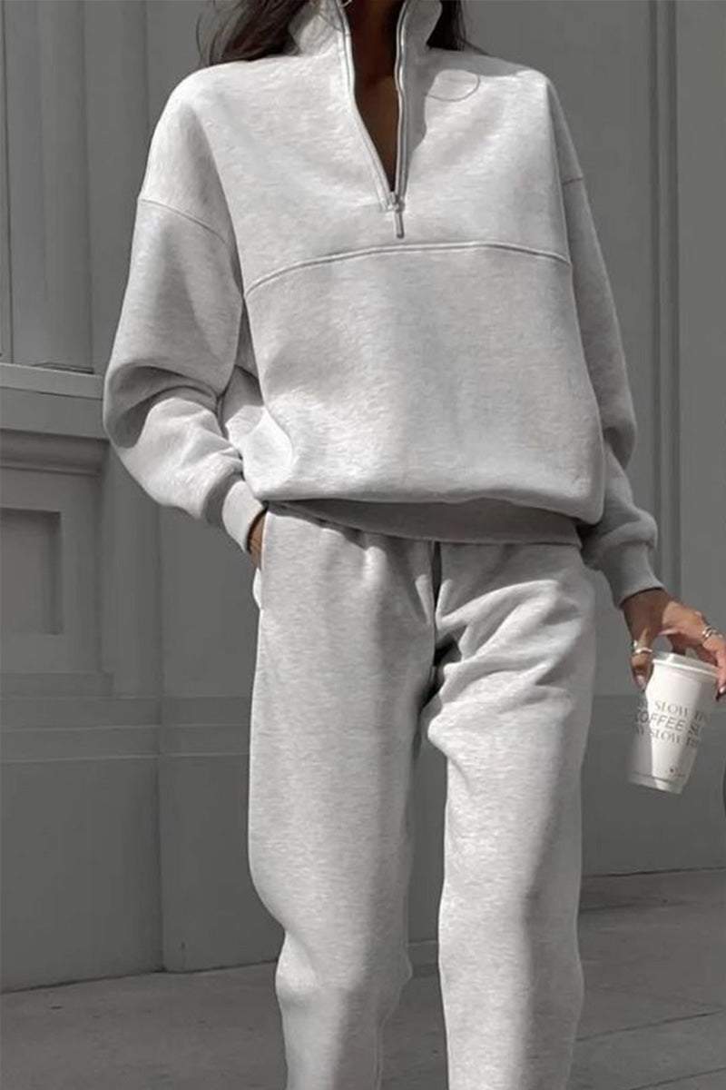 Light gray cotton-blended two-piece tracksuit with high collar and deep zipper, modeled outdoors holding a coffee cup.