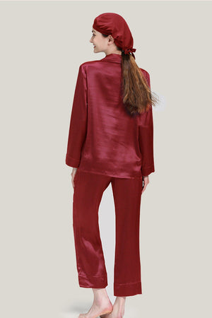 Woman wearing classic red mulberry silk pajama set with matching sleep cap from back view