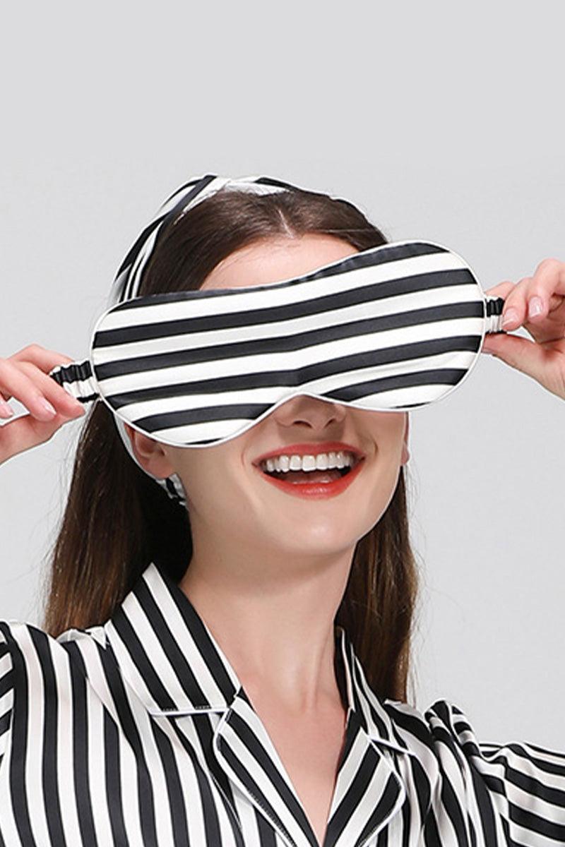 Woman wearing black and white striped mulberry silk sleepwear with matching eye mask