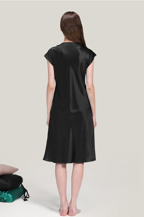 Back view of a woman wearing a black Mulberry Silk V-Neck Nightgown with short sleeves and knee-length hem