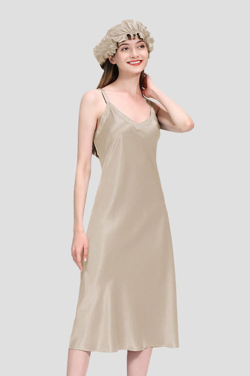 woman wearing beige mulberry silk elegant night dress and matching silk bonnet on gray background