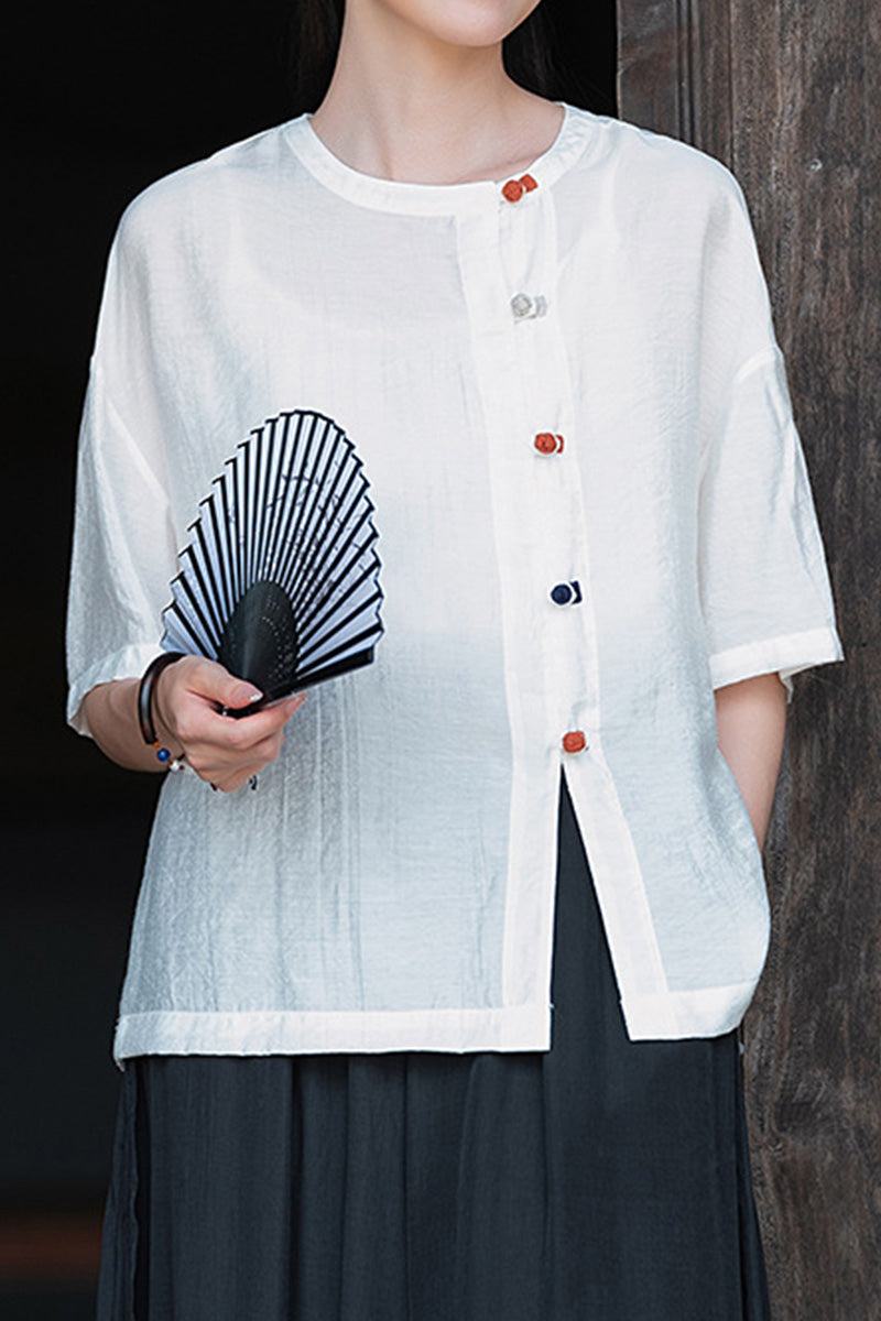 Lightweight white regenerated cellulose blouse with asymmetrical multicolor buttons, oversized fit, and breathable fabric.