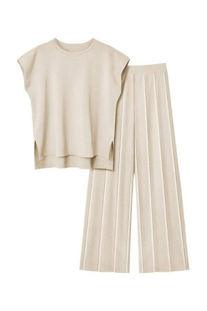First Class Travel two-piece beige set with pleated wide-leg pants and relaxed top, wrinkle-resistant, breathable fabric.