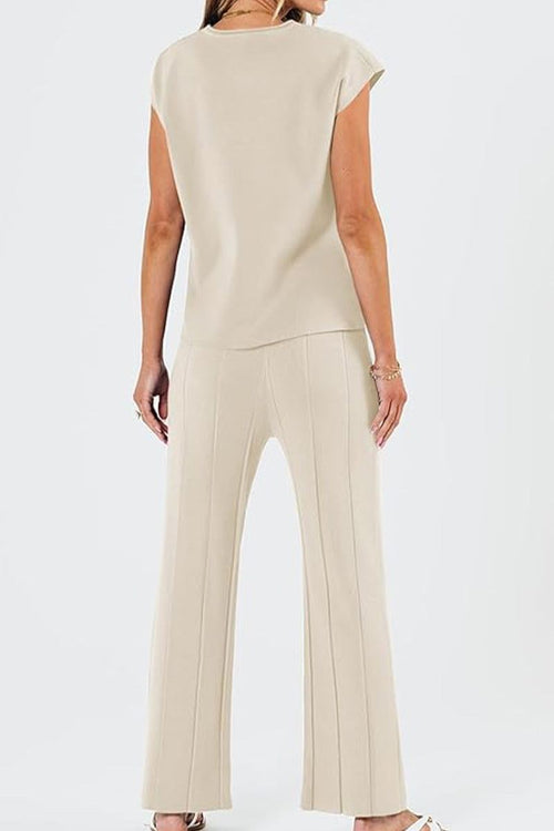 Woman wearing beige First Class Travel comfort two-piece set with pleated wide-leg pants and short-sleeve top, back view