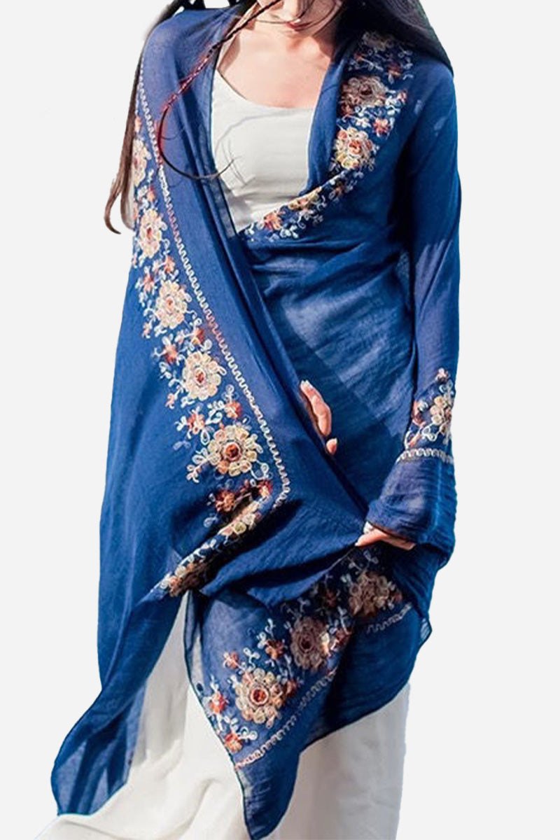 Blue embroidered travel-must shawl wrap with floral design worn over white outfit