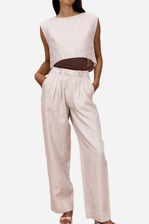 Woman wearing breathable cotton-linen blend two-piece summer outfit with cropped top and wide-leg pants, beige color