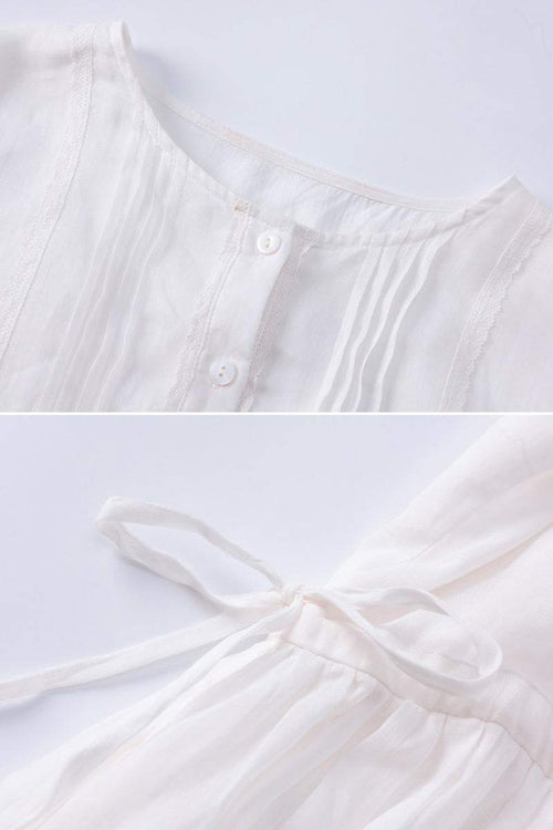 Close-up of white 100% linen coastal shift dress showing button front and waist tie detail