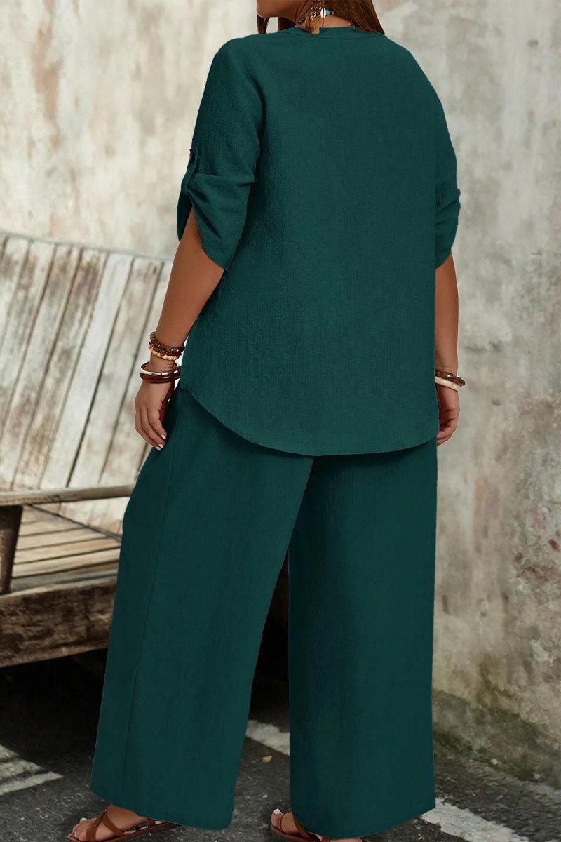 Woman wearing a dark green wrinkle-free wide leg pants and button-front top set, comfortable and travel-ready outfit