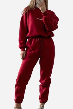 woman wearing red Storm Sweater Mock Neck athleisure set with relaxed fit and adjustable waist