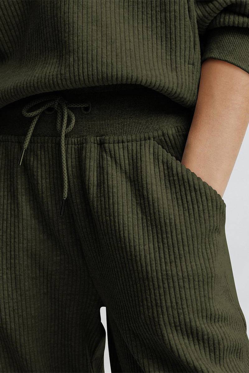 Close-up of unisex half-zip pullover and sweatpants set in olive green ribbed fabric with drawstring waist and hand in pocket