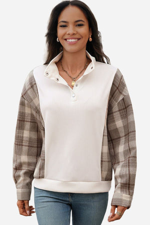 Woman wearing waffle knit sweatshirt with plaid sleeves and button neckline, casual comfortable style
