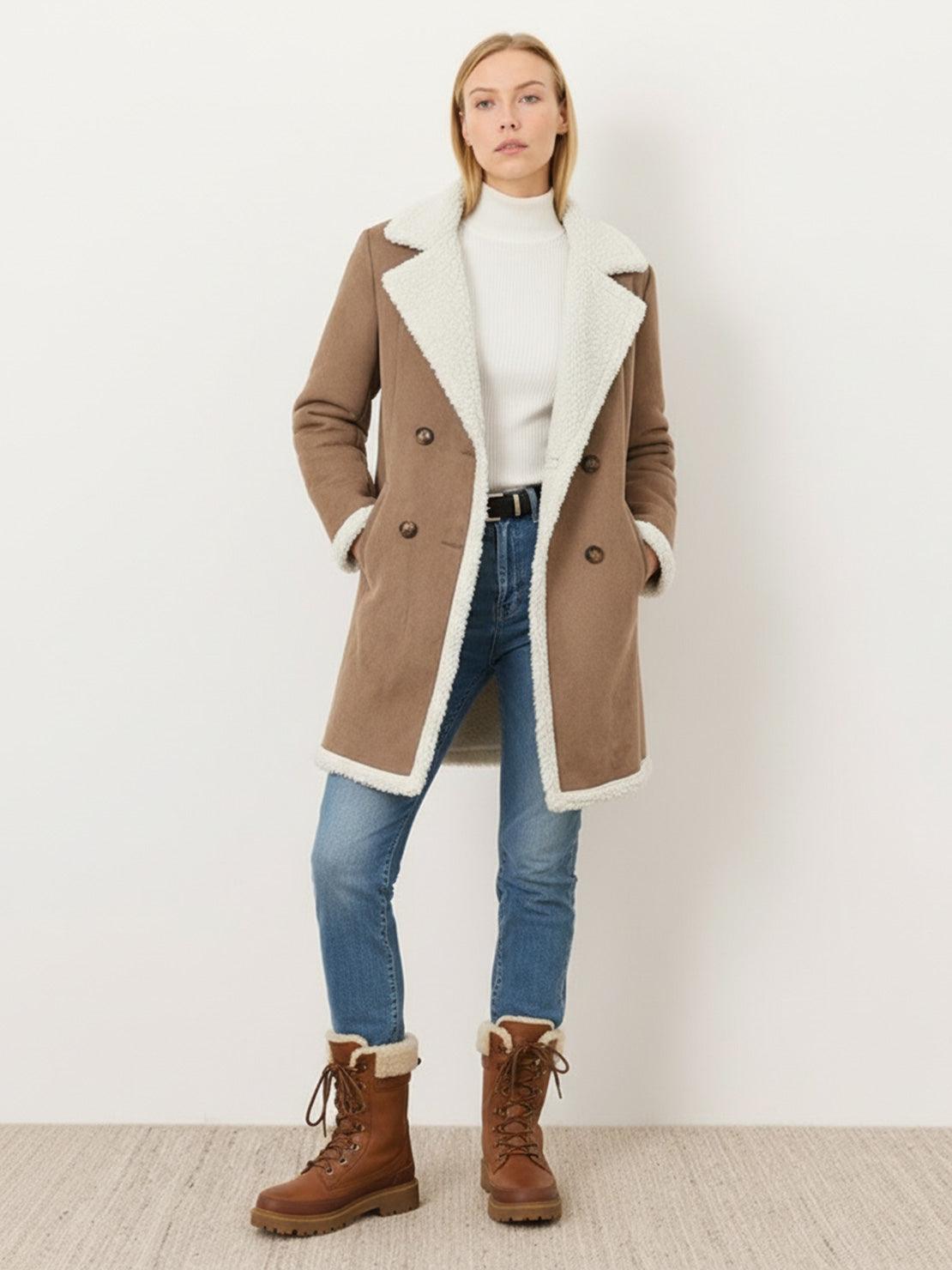 Woman wearing a mid-thigh faux suede sherpa coat with contrast sherpa collar and side pockets