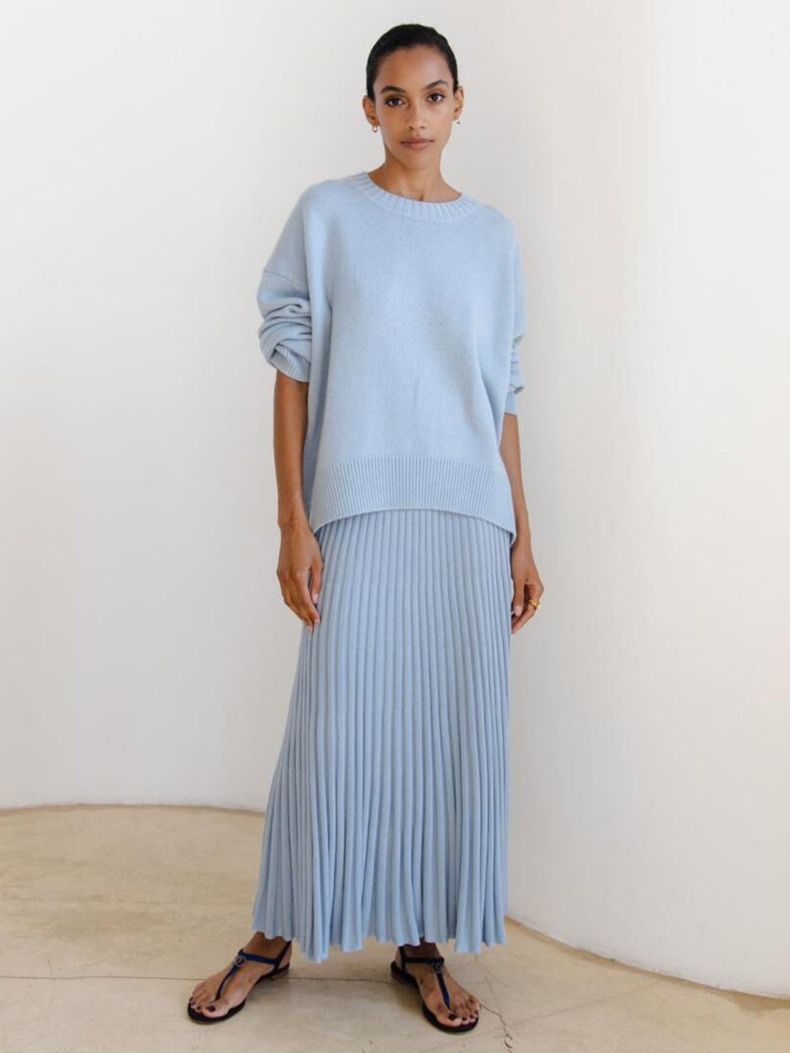 Oversized crew neck knit sweater with drop-shoulder sleeves and ribbed cuffs, medium-weight acrylic fabric.