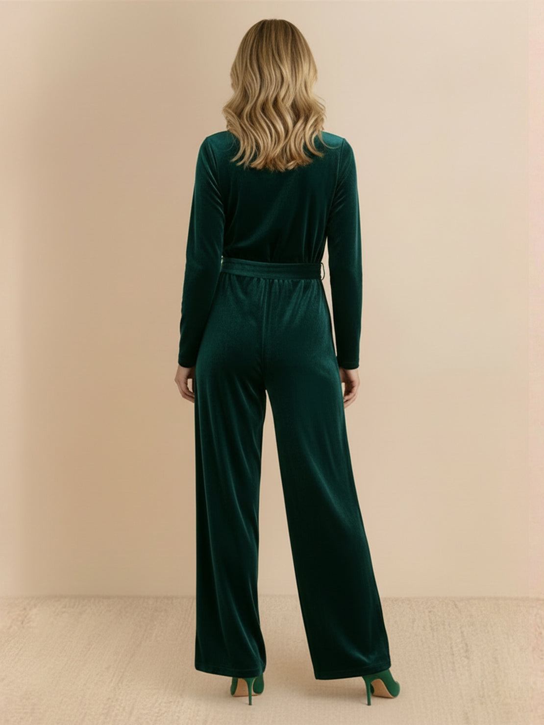 Woman wearing a deep V-neck velvet suit with long sleeves, removable waist tie, and wide-leg pants.