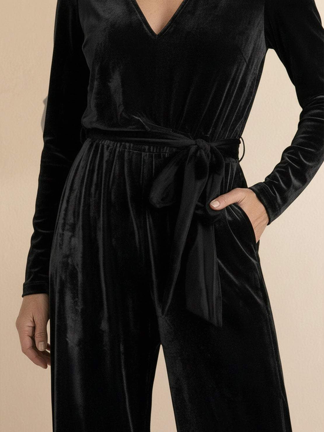 Woman wearing deep V-neck velvet suit with long sleeves and wide-leg pants
