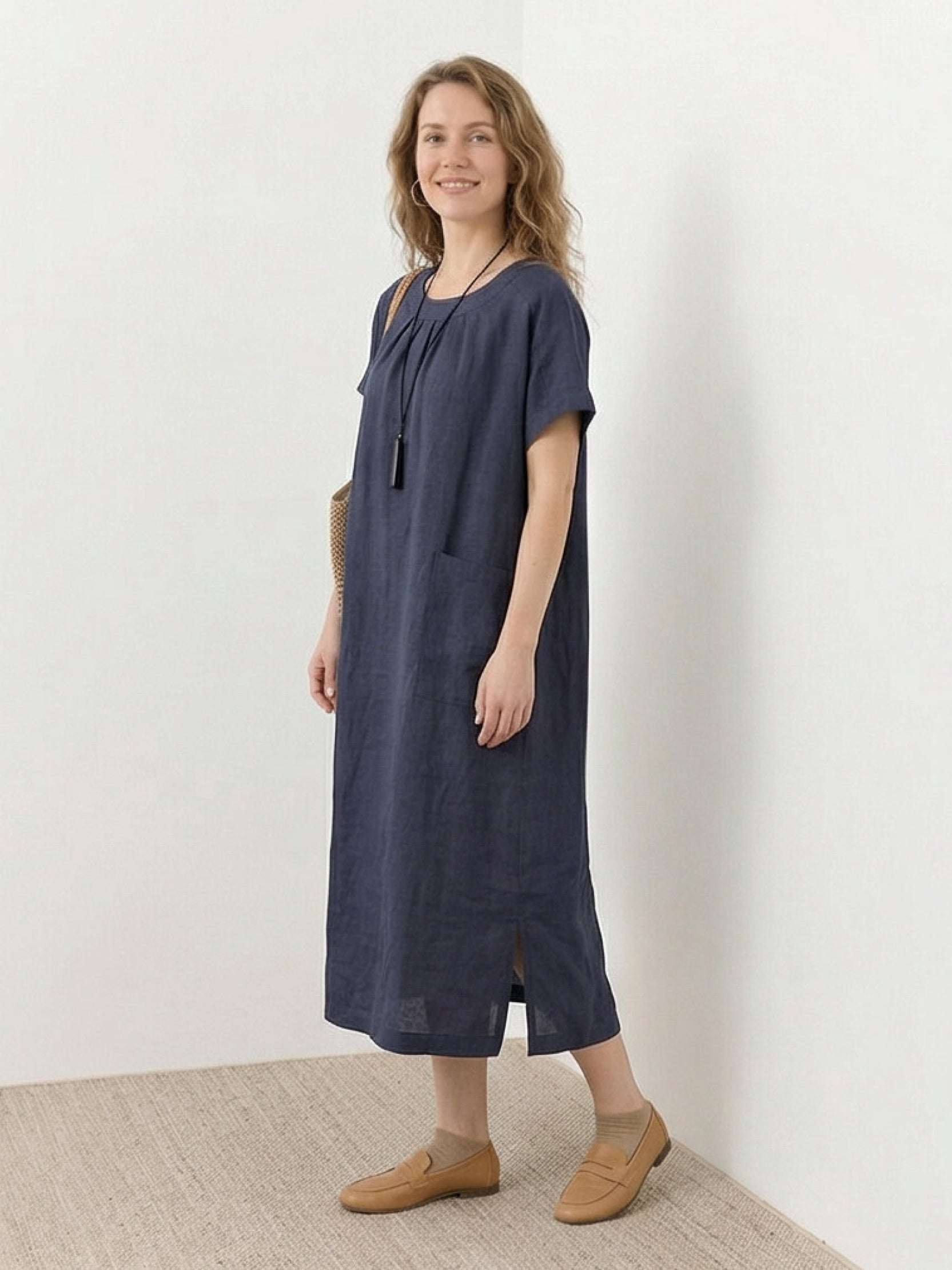 100% linen pocket midi dress with relaxed fit, short sleeves, and small side slits for comfort and ease of movement