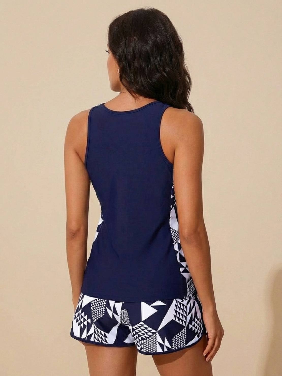 Woman wearing racerback two-piece tankini set with tropical print swim shorts and scoop neckline top