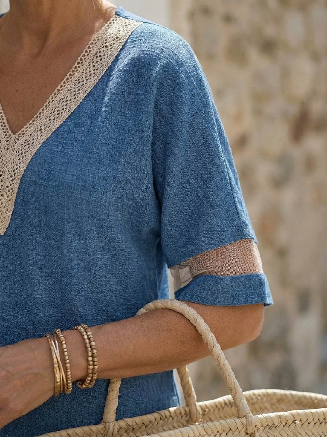 Mature woman wearing a lightweight linen top with short sleeves, V-neckline, and three-button front detail in light khaki color
