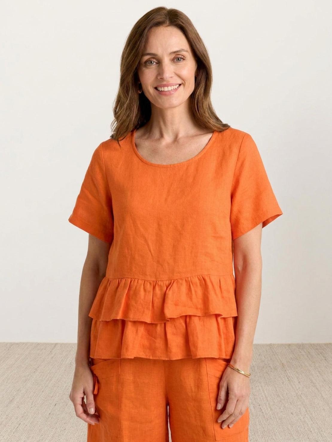 Woman wearing navy blue cotton relaxed shorts and matching ruffle-detail top summer co-ord set