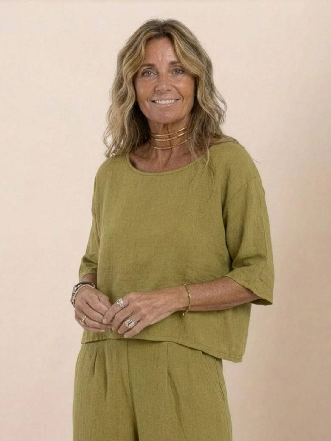 Woman wearing mustard yellow short-sleeved pullover and wide trouser matching set with relaxed fit