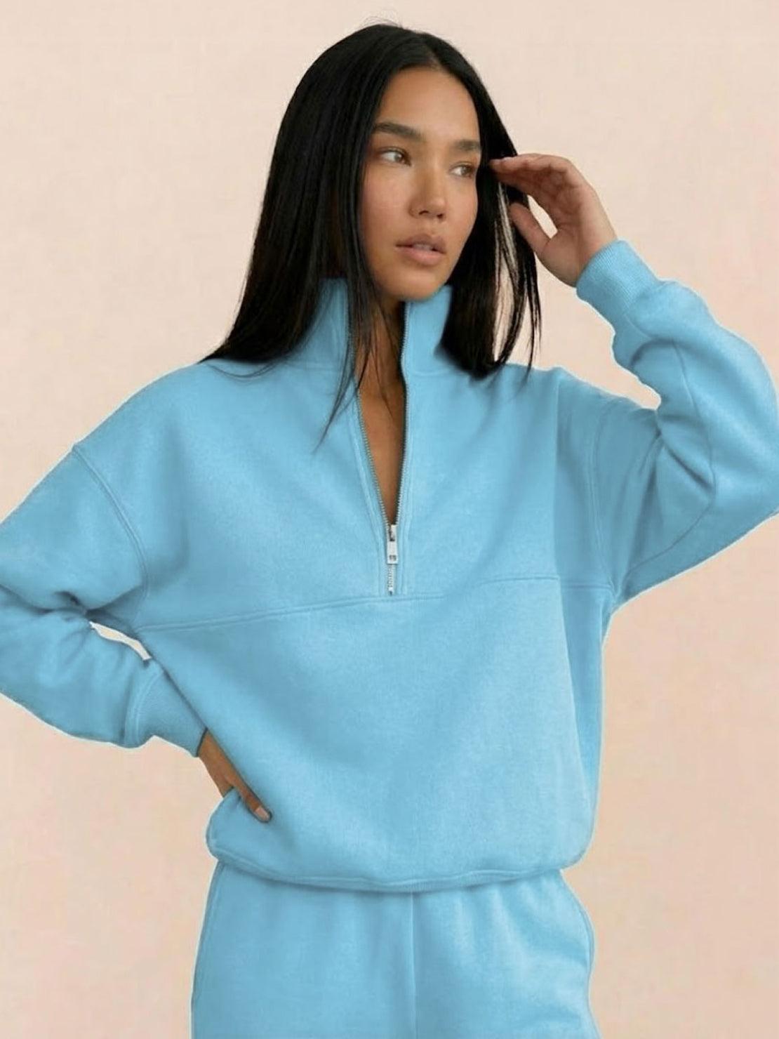 Woman wearing a cotton-blended two-piece tracksuit with high collar and deep zipper in casual athleisure style