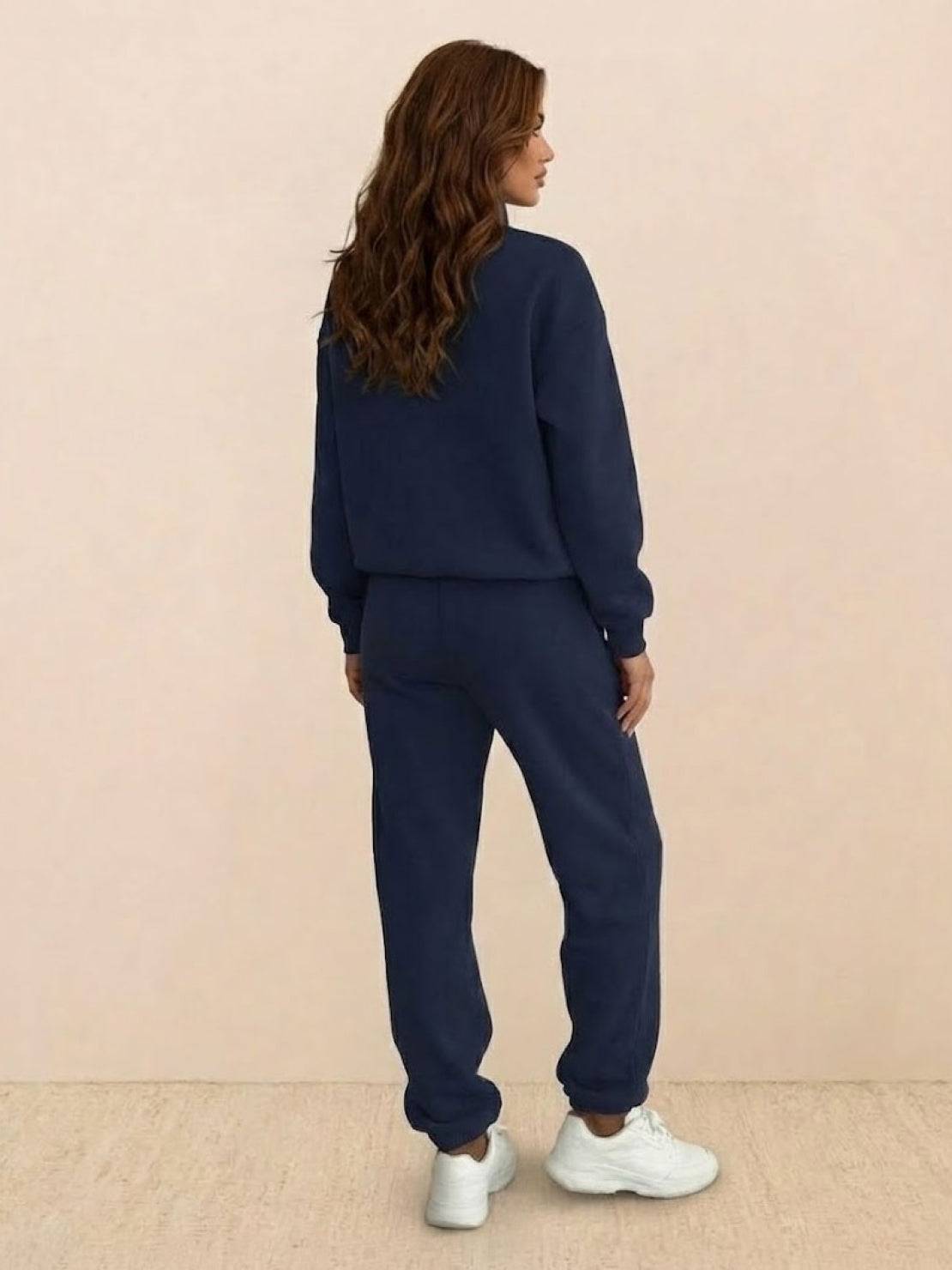 Woman wearing a stylish cotton-blended two-piece tracksuit with high collar and zipper, showcasing casual confident athleisure style