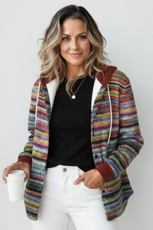 Woman wearing colorful Highland Plaid Shacket with hood and white jeans, holding coffee cup