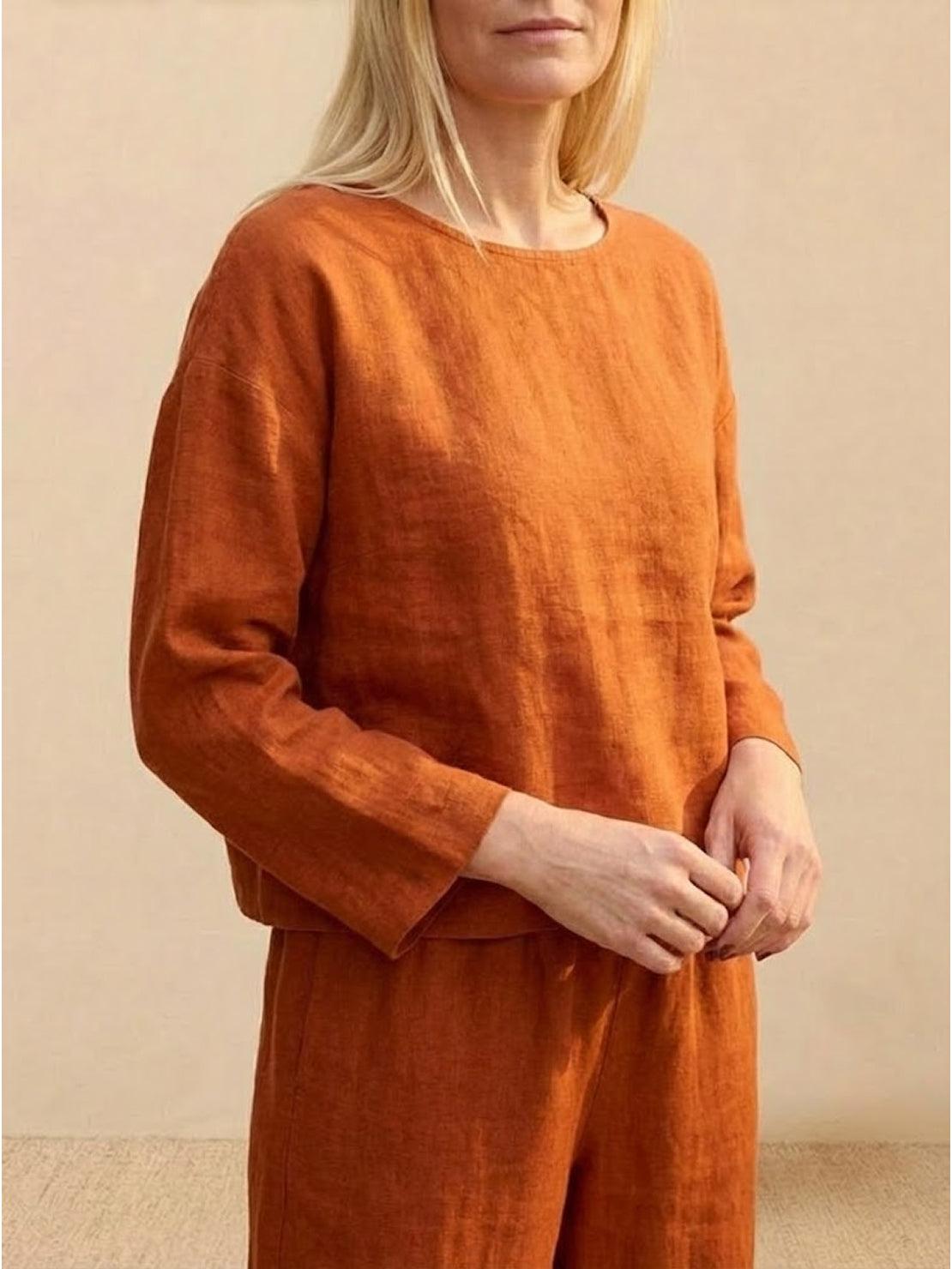 Loose solid color two-piece set in breathable linen-feel fabric, featuring a relaxed fit pullover and wide-leg pants in burnt orange.