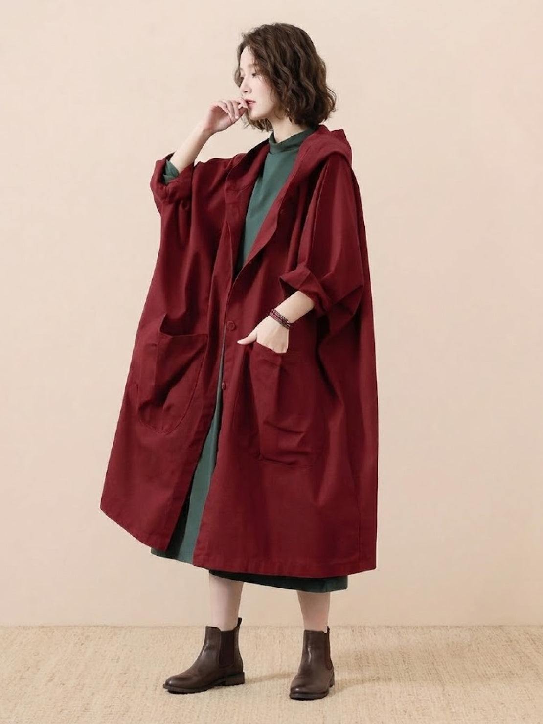 woman wearing oversized water-resistant windbreaker jacket with waterproof design in burgundy color