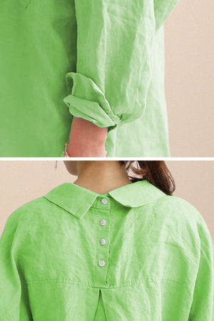 Close-up of oversized linen shirt in light green with rolled sleeves and back button detailing