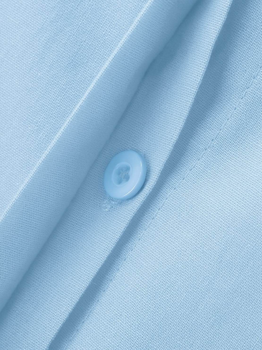 Close-up of oversized 100% cotton shirt fabric and button in light blue color