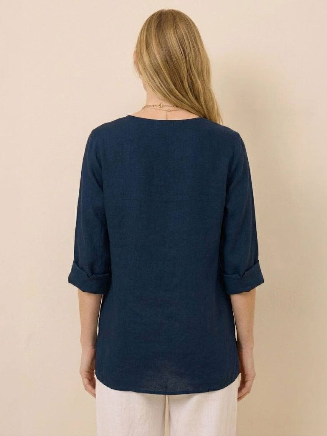 White pure linen age-defying shirt with button detail displayed on hanger against white background