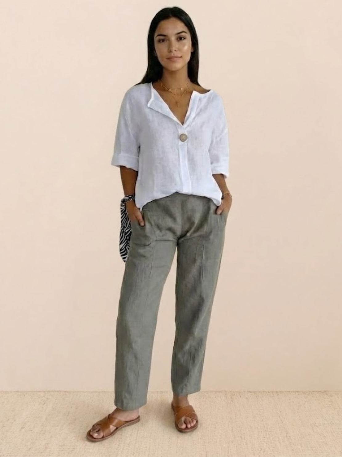 White pure linen age-defying shirt with button detail on a hanger against white background