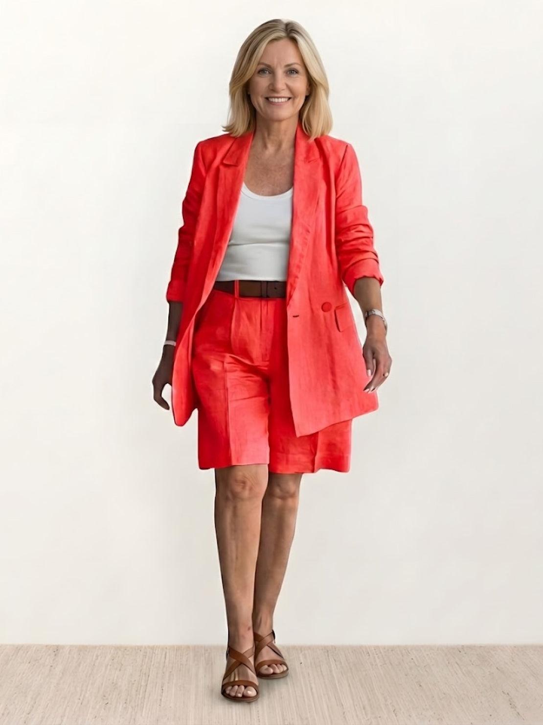 woman wearing stylish blazer and shorts two-piece set standing against white background