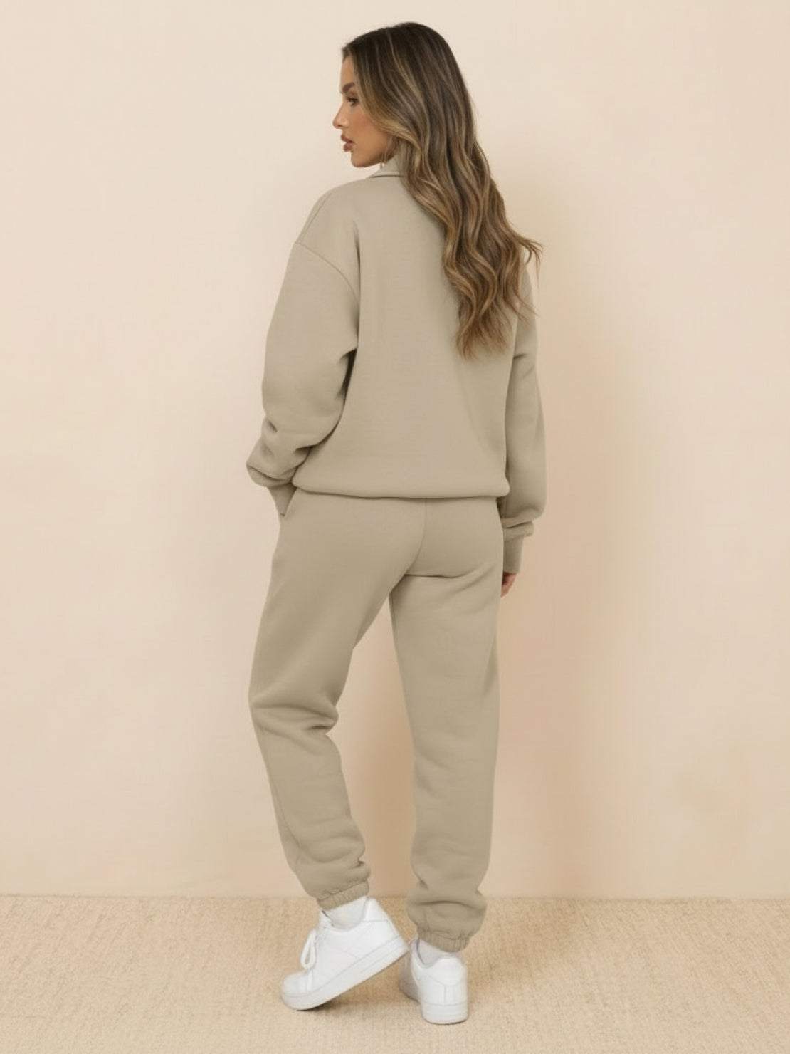 Woman wearing ultra-soft and comfy co-ord tracksuit set in khaki color, standing against beige background
