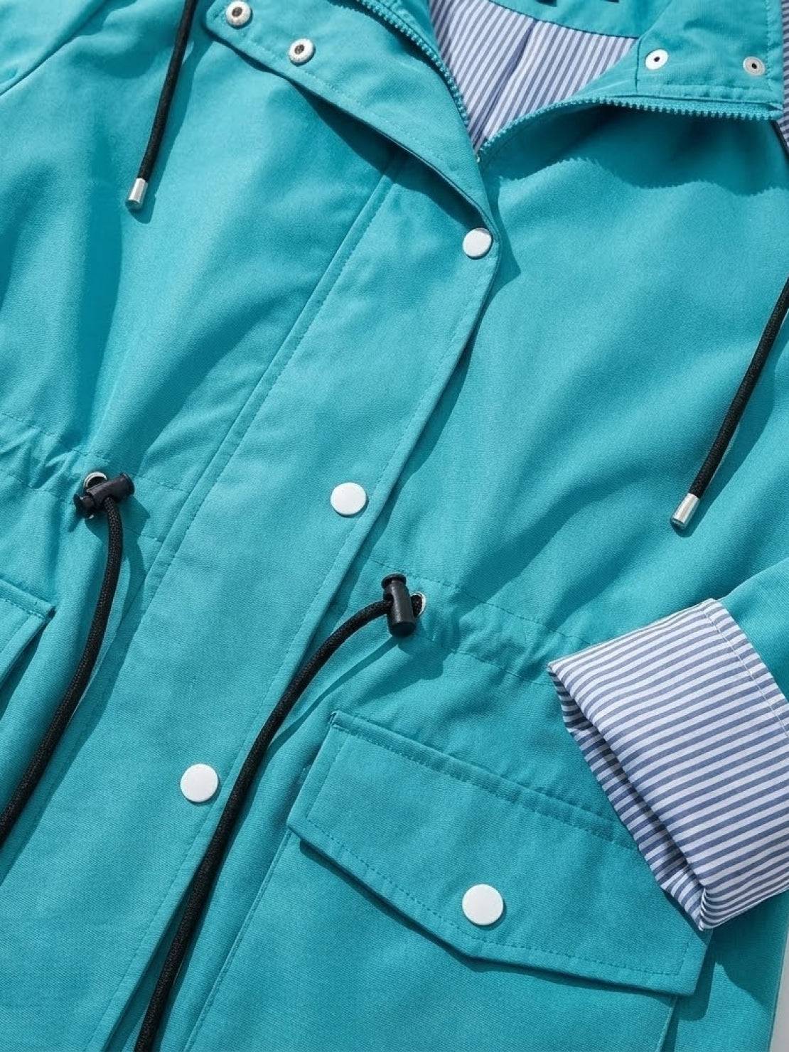 Teal water resistant windbreaker jacket with hood, striped inner lining, adjustable waist drawstring, and multiple pockets.