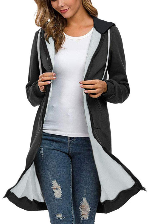 Oversized long zip sweatshirt hoodie in black with fleece lining, drawstring hood, and large front pockets worn over white top and jeans