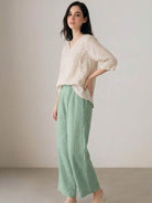 Woman wearing 100% cotton linen blend golden hour set with embroidered top and wide-leg trousers
