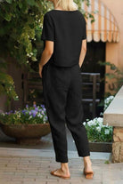 Woman wearing black breathable cotton linen set with relaxed top and straight-leg pants outdoors