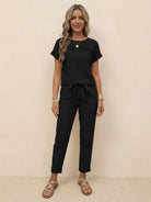 Woman wearing black 100% cotton total comfort two-piece travel set with short sleeves and drawstring pants