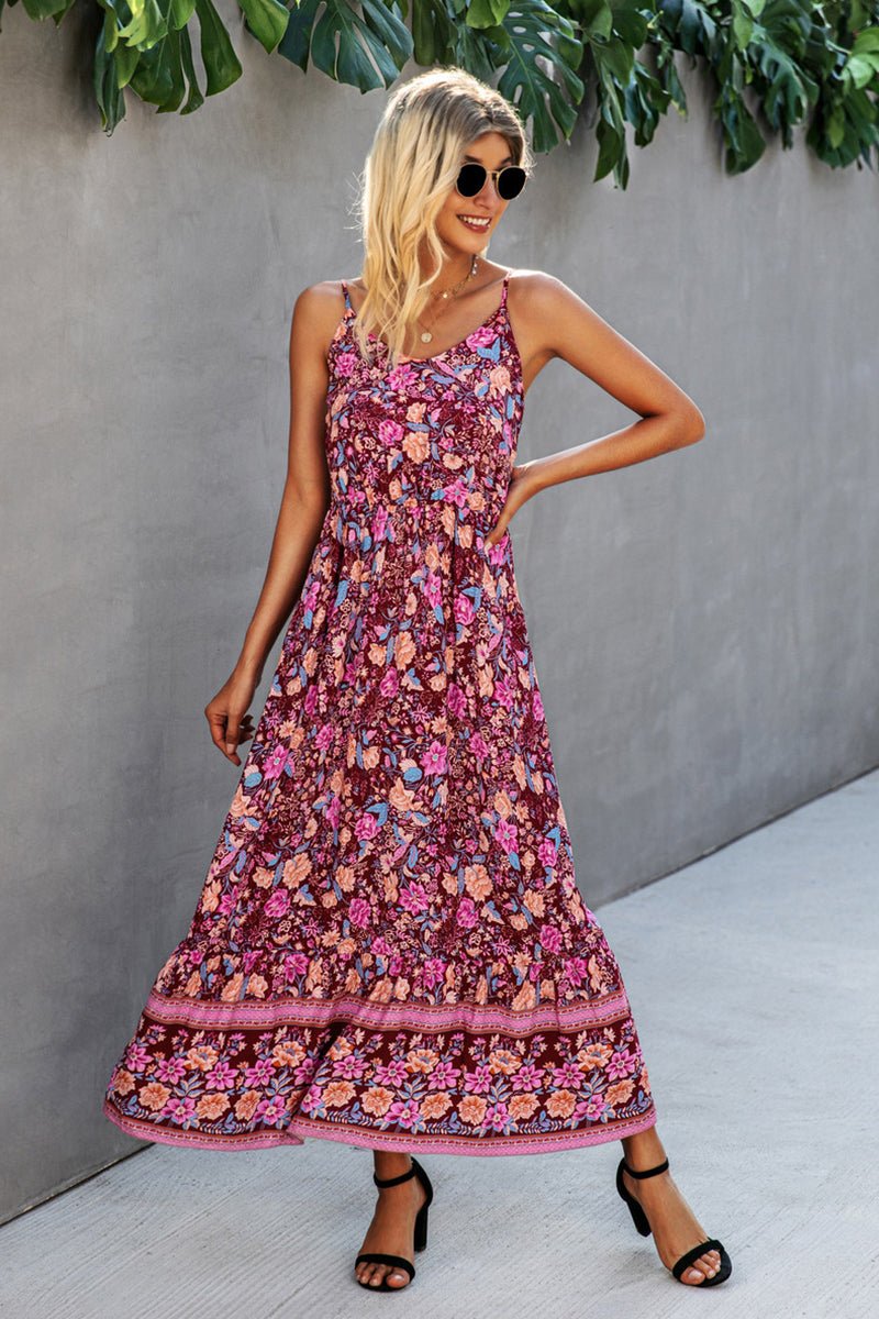 Woman wearing a vintage flower prints maxi dress with spaghetti straps and open back standing outdoors