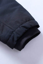 Close-up of sleeve cuff on thick long-sleeve zipper overcoat showing durable fabric and elastic ribbing detail