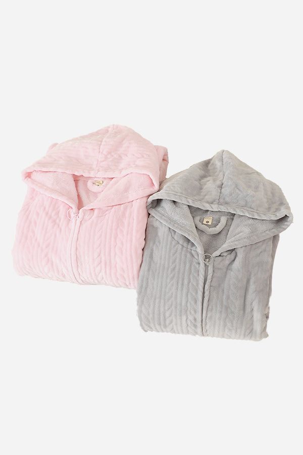 Folded stylish flannel nightgowns in soft pink and gray with hoods and front zippers.