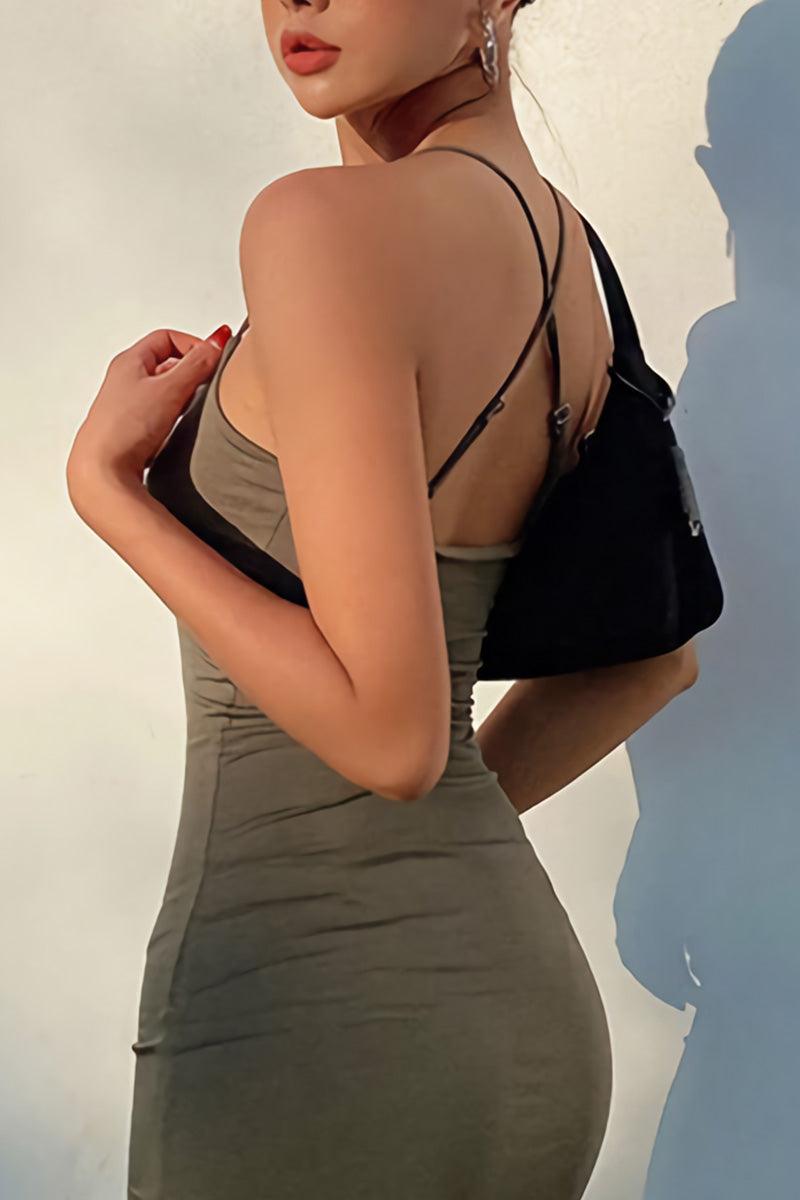 woman wearing elegant side slit midi dress with thin straps and carrying black handbag