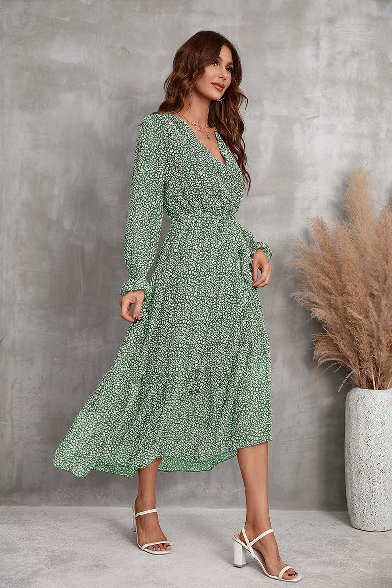 Woman wearing green floral Bloom Wrap Midi Dress with A-line silhouette and trumpet sleeves